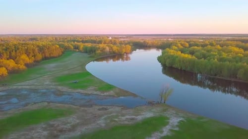 Wunderschöner Blick auf den malerischen, gewundenen Fluss, umgeben von Wald bei Sonnenuntergang