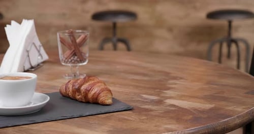 Croissant and Coffee on a Wooden Table