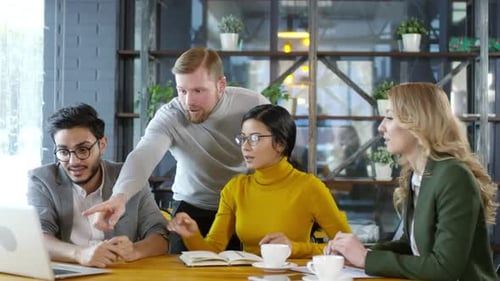 Successful Business Team Smiling and Giving High Five in Cafe