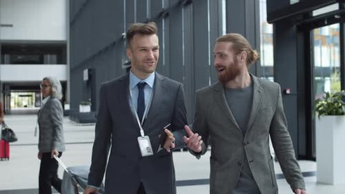 Two Businessmen Talking in Airport