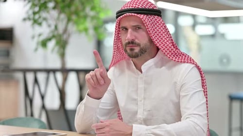 Man in Traditional Dress Warns with Finger Gesture