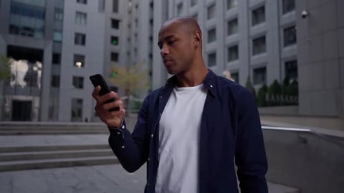 Ethnic Man Using Smartphone on Street