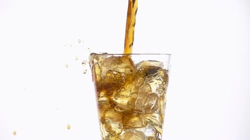 Brown Liquid Poured into Glass with Ice