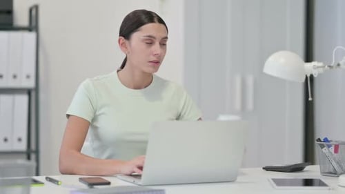 Junge lateinamerikanische Frau trinkt Kaffee und arbeitet am Laptop