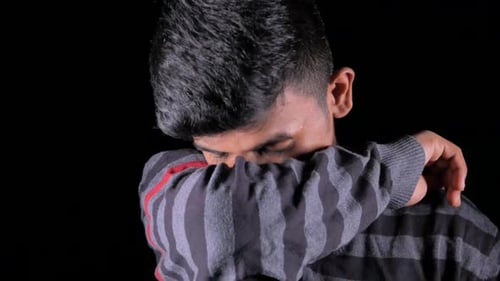 Jeune homme malade se couvrant le nez et la bouche avec un bras.