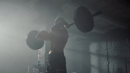 Sportsman Standing with Barbell on Shoulders