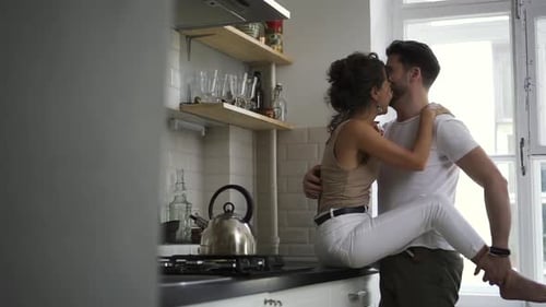 Romantic Couple Embracing and Kissing in Kitchen