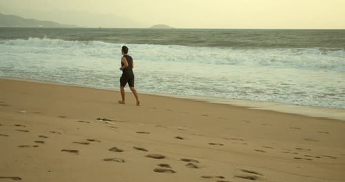Joven caucásico hace ejercicio corriendo al aire libre con un hermoso fondo de mar