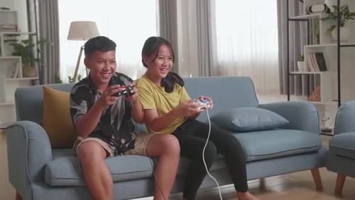Funny Asian Children With Joystick Game Playing Video Games At Home
