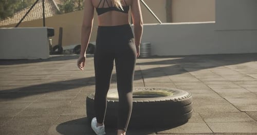 Athlete Lifting And Pushing Tire In Outdoor Gym