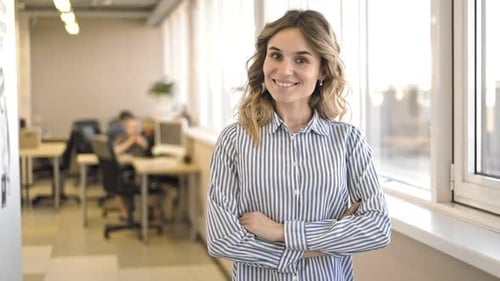 Business Woman with Crossed Arms Standing in Office Smiling and Posing at Camera