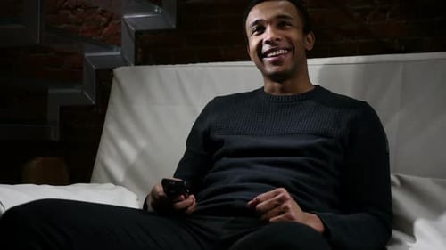 Man Relaxing on Couch Watching TV