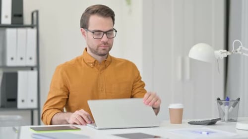 Man Opens Laptop to Work at Desk