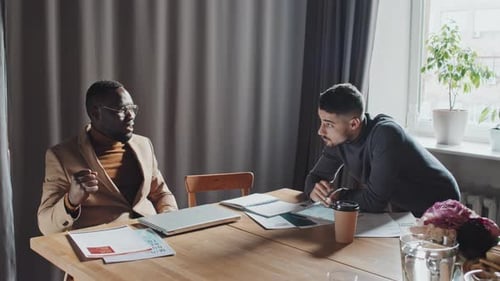 Coworkers Confer and High Five in Office