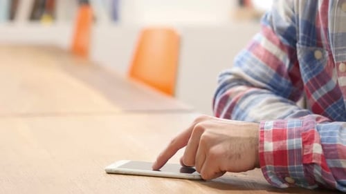 Man Using Smartphone on Wooden Table, Close Up