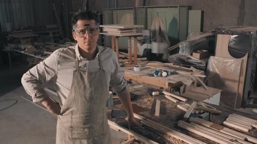 Carpenter Stands in Workshop Wearing Safety Glasses