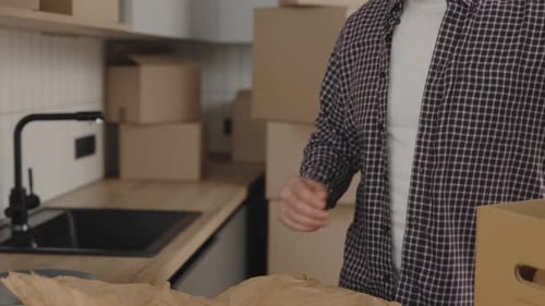 Man Packing Boxes at Home, Getting Ready to Move