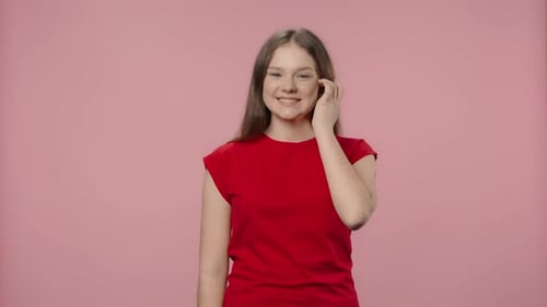 Smiling Young Woman in Red T-Shirt on Pink