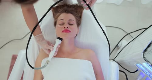 Beautiful Woman at a Cosmetologist's Reception Receives a Vacuum Massage of the Skin of the Face