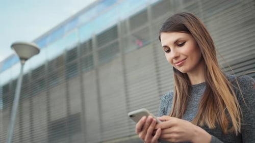 Young Woman Using Smartphone in Urban Setting