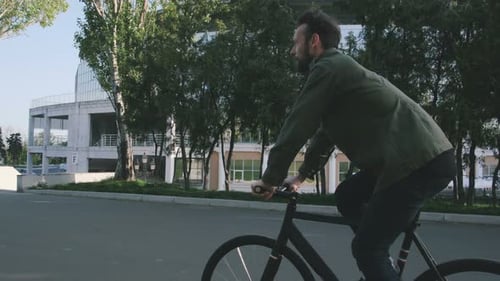 Tracking Shot of Hipster Man Riding Fixed Gear Bicycle in Park