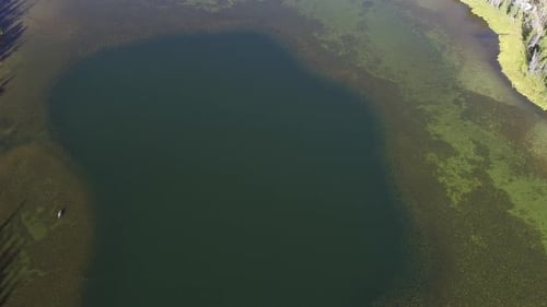Aerial view above lake moving down towards the water