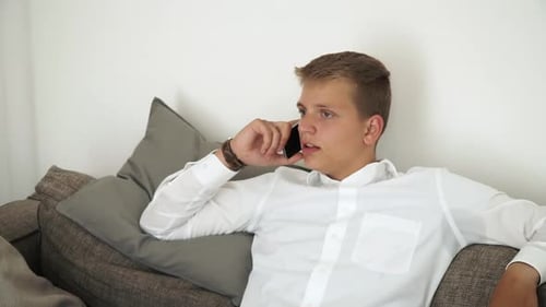 Man Talking on Cellphone While Relaxing on Couch