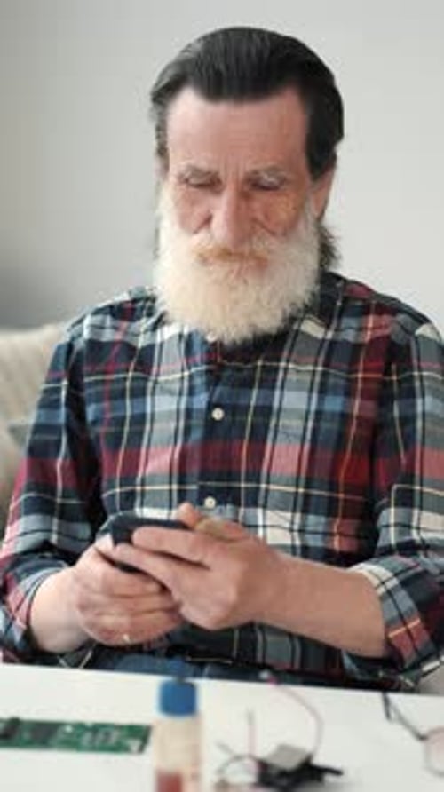 Senior Man Using Phone at Home