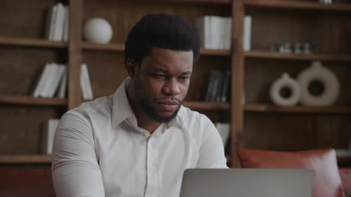 Young Adult Businessman is Focused on Working on His Laptop in Loft Office