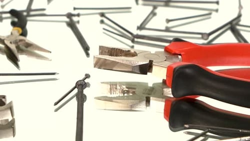 Pliers and Nails on White Reflective Surface