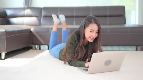 Woman Lying Down Uses Laptop at Home