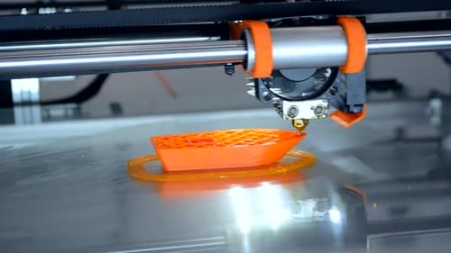 3D printer creating orange plastic boat