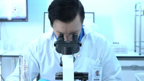 Scientist looking through microscope