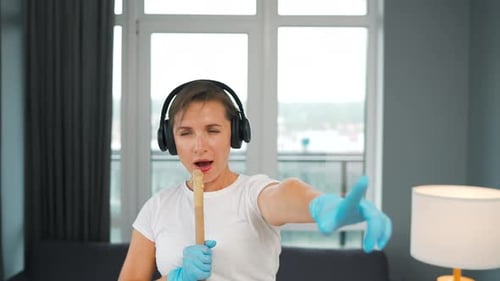 Woman Singing and Dancing with Mop at Home