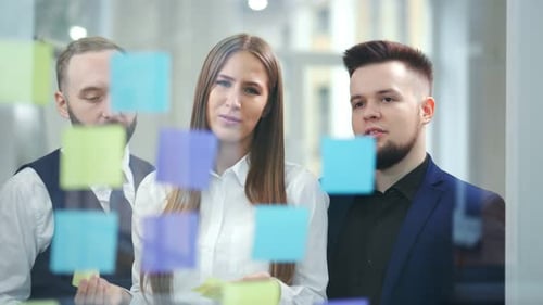 Young Adults Brainstorming Ideas Using Sticky Notes