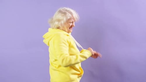 Stylish Granny in a Yellow Sports Sweatshirt Moving To Music, Dancing Party, Style