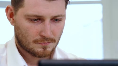 Man Works at Computer in Bright Office