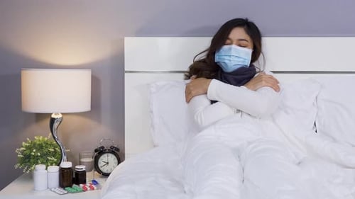 Woman Lying in Bed Wearing Protective Mask
