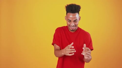 Studio Portrait of Cheerful Black Guy Dancing Over Orange Background