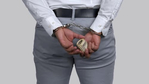 Arrestado hombre de piel oscura con un retorcido montón de dinero