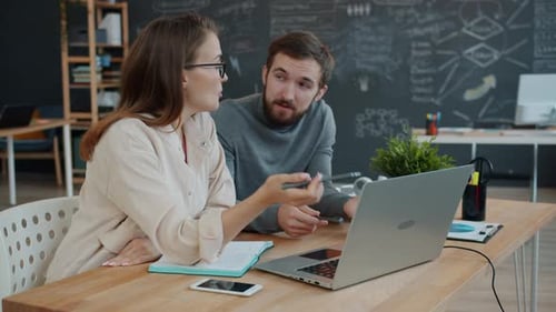 Specialists Male and Female Sharing Business Ideas in Office Looking at Laptop Screen