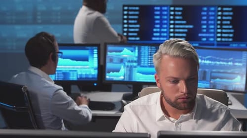 Diverse team of brokers workin in office using workstation and analysis technology.