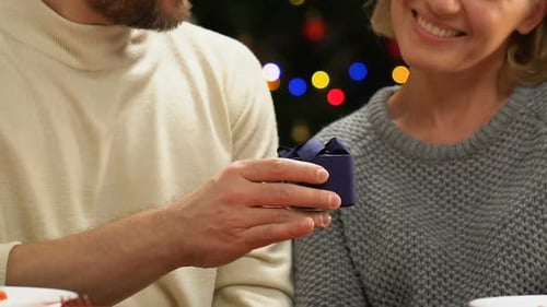 Woman Receives Gift From Man at Christmas
