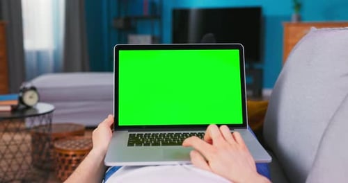 Man Working on Green Mockup Screen Laptop Computer