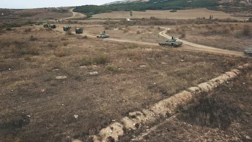 Vue aérienne de chars en colonnes partant d'une base militaire