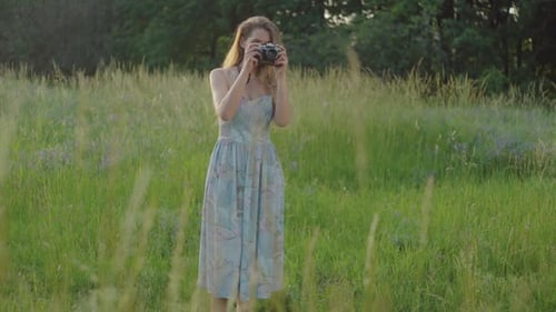 Woman Photographing in Grassy Rural Field With Vintage Camera