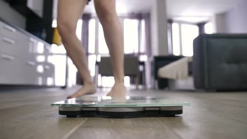 Woman Steps on Scale for Weight Measurement at Home