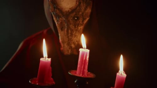 Ominous Masked Figure With Candles in Dark Setting