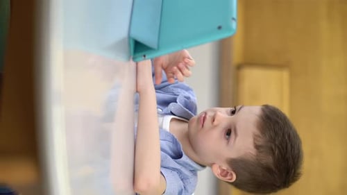 Boy Using Tablet at Table Indoors Portrait