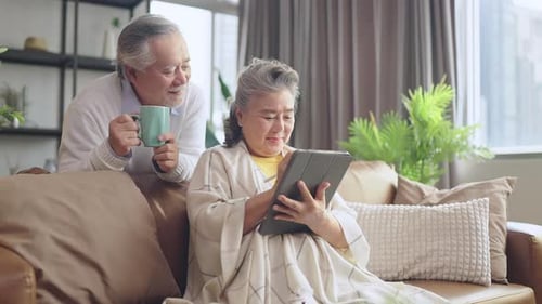 Senior Couple Relaxing Together with Tablet at Home